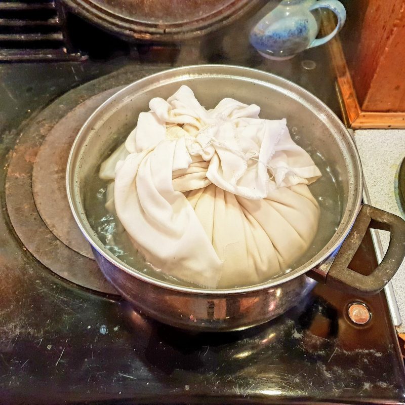clootie dumpling boiling in a pan of water