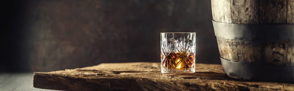A glass of whisky and a whisky barrel