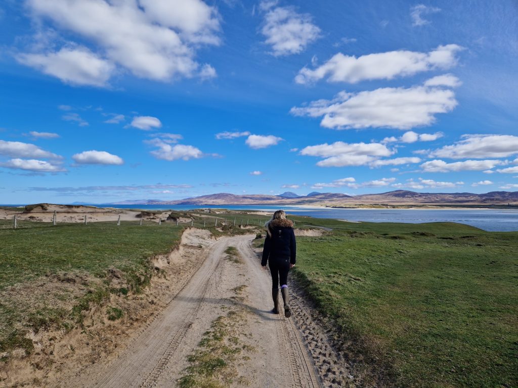 person walking on sandy track