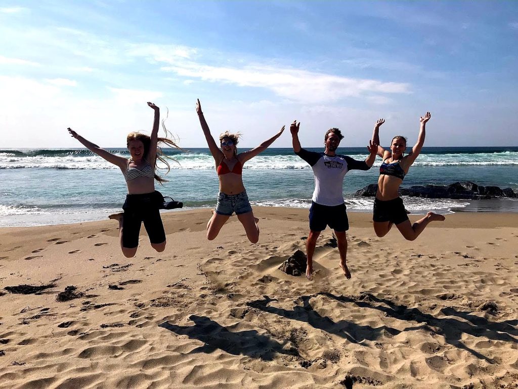A group of people jumping on the sand