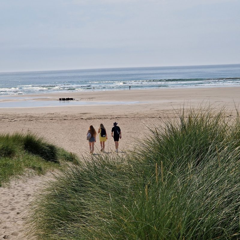 People walking onto beach