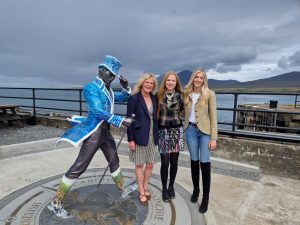 Johnnie Walker statue and three ladies beside it