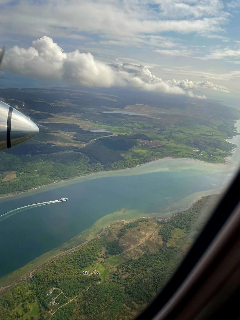 plane flying over ferry in sea