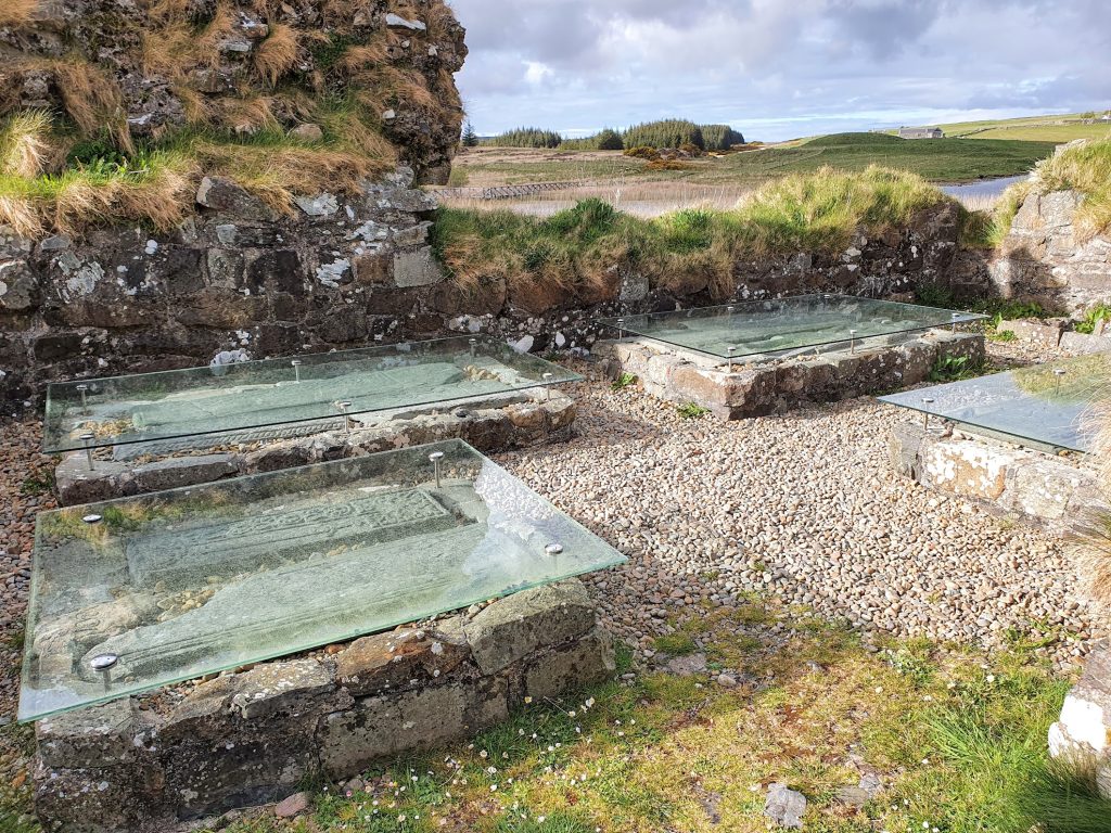 glass covered carved burial stones by ruins