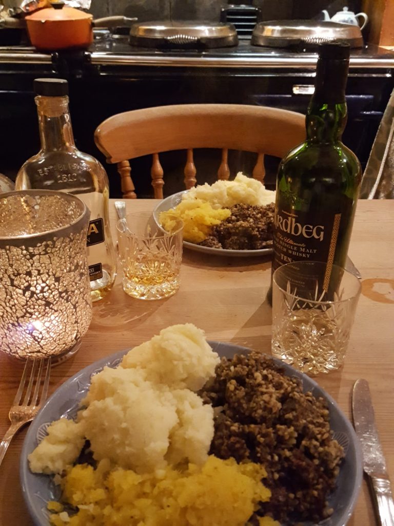 Bottle of Ardbeg whisky and a plate of haggis and neaps and potato